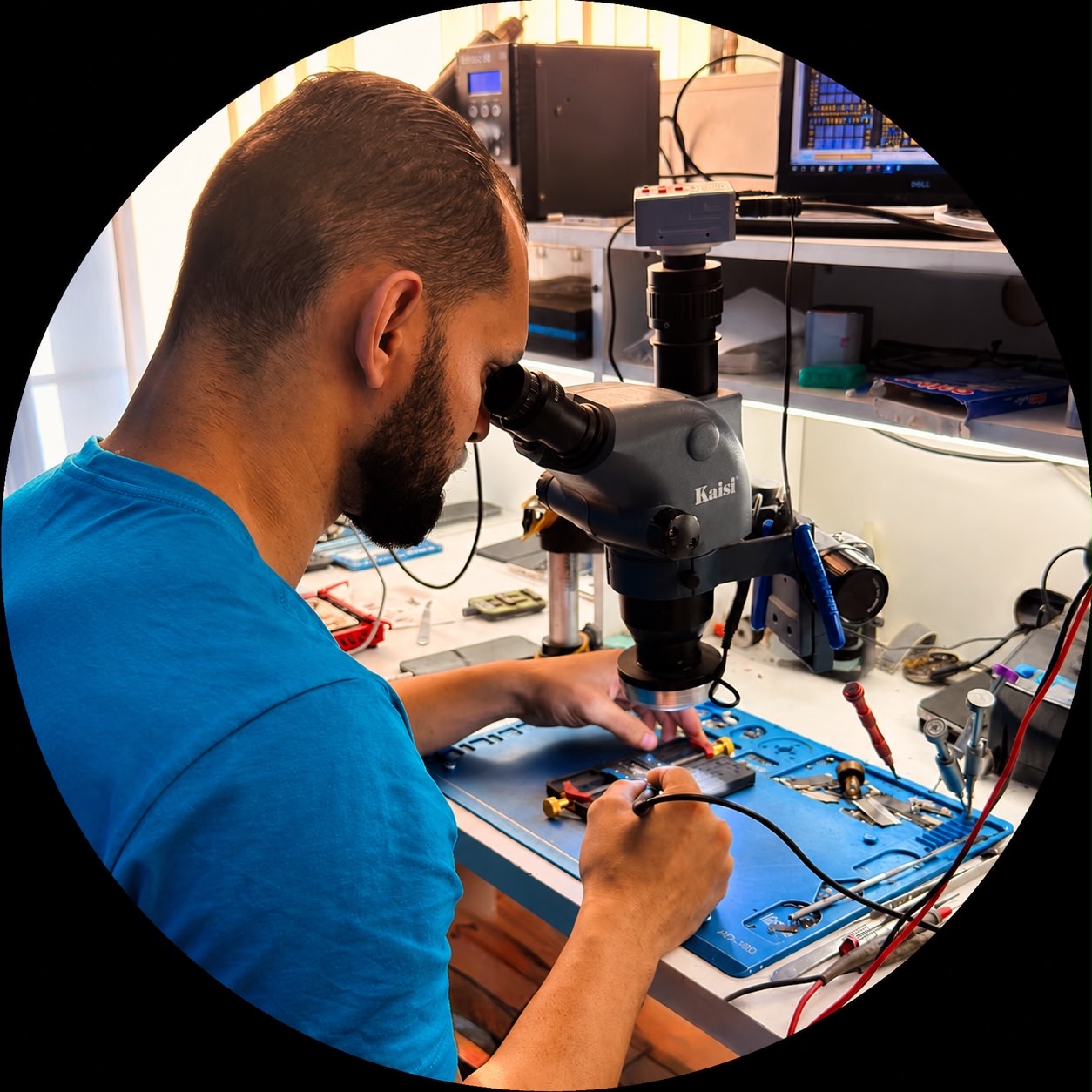 Técnico IdTouch analisando placa de iPhone no microscópio